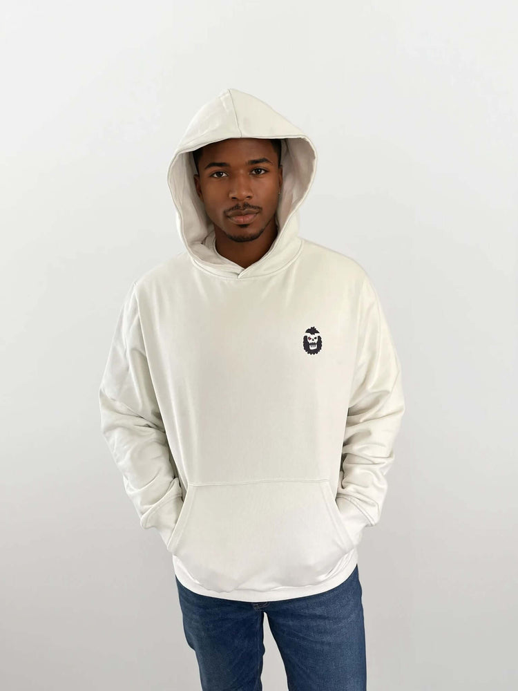 Man wearing a white hoodie with a Bigfoot 2099 design on the chest, showcasing a modern and stylish look.