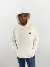 Man wearing a white hoodie with a Bigfoot 2099 design on the chest, showcasing a modern and stylish look.