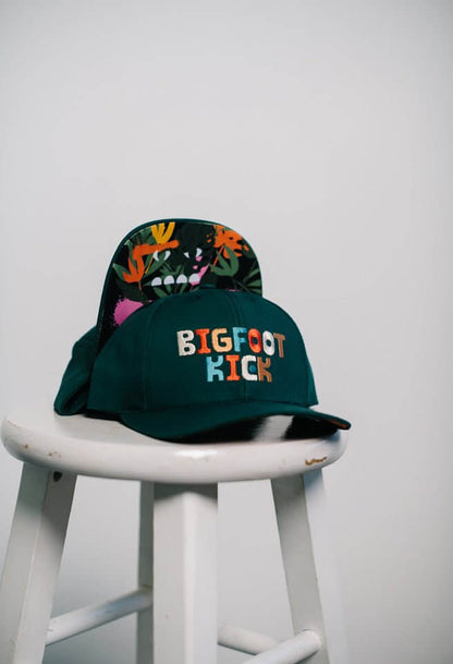 Hidden Bigfoot Hat displayed on a stool showcasing its unique Bigfoot-themed design.